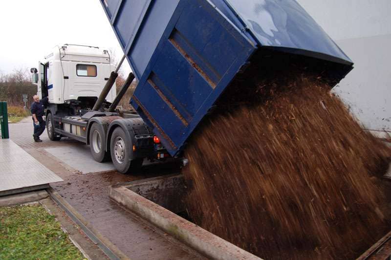 LKW der seinen Frachtraum in eine Art Grube entleert