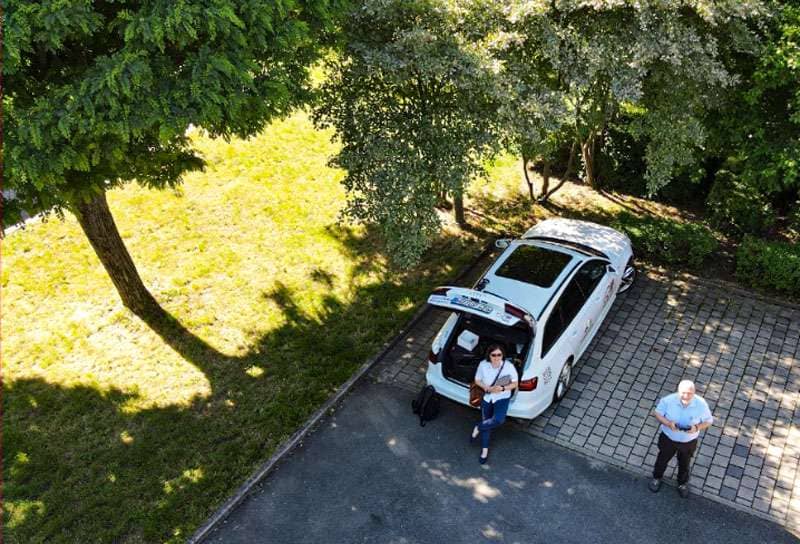 Oben Ansicht auf ein geparktes Auto neben einer Wiese